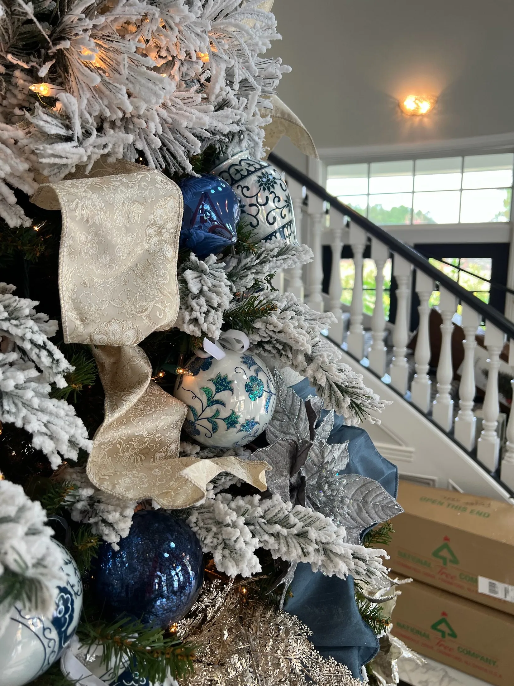 Close-up of blue, silver, and velvet decorations on a real Christmas tree