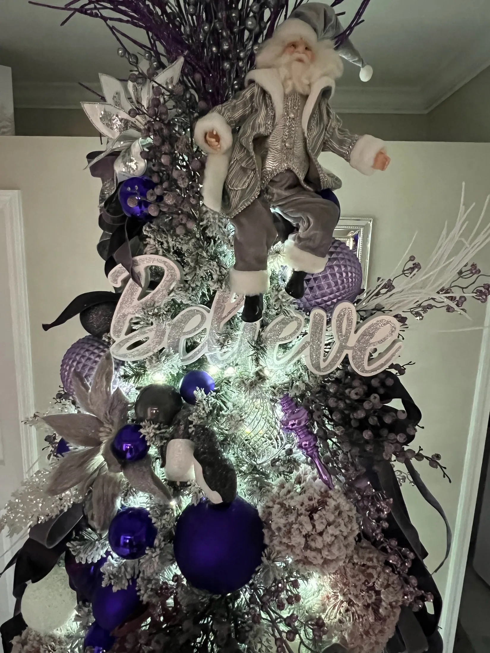 Close-up of a real lavender and silver Christmas tree with a Santa topper