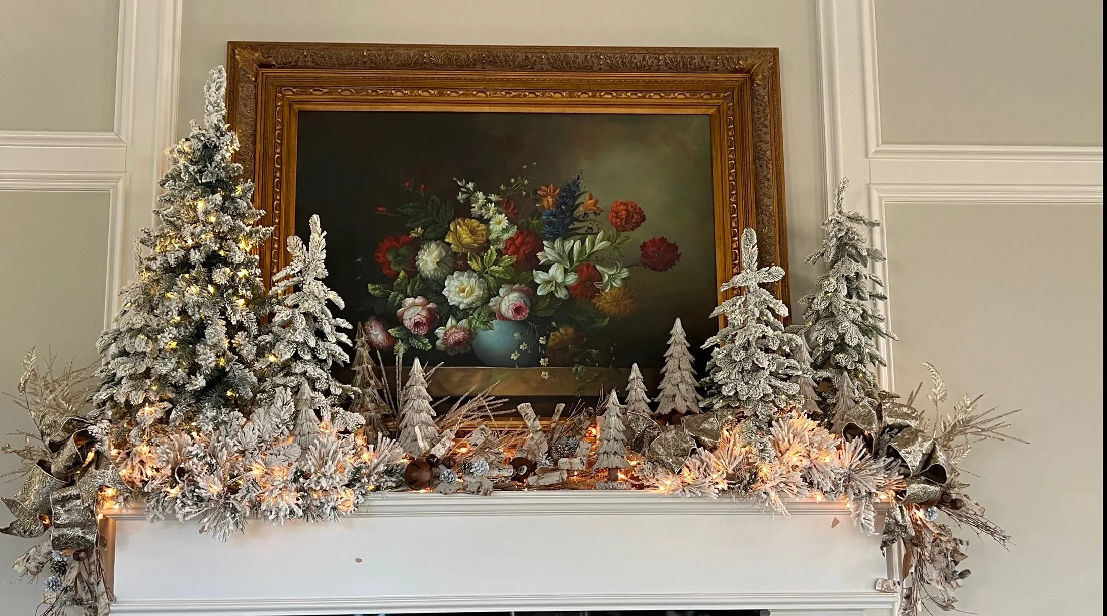 A real Christmas mantel styled with frosted trees and silver evergreen details