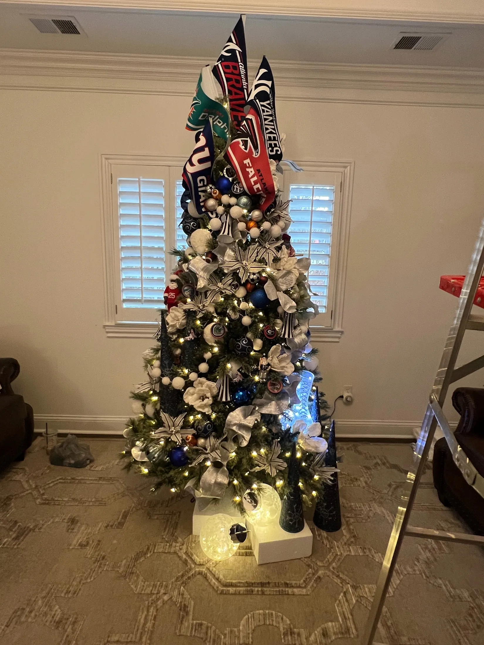 A real Christmas tree styled with sports team decorations and silver ribbon